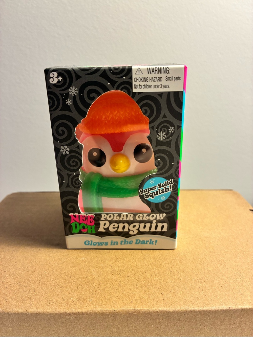 “NeeDoh” Polar Glow Penguin Squishy Toy - Orange Hat, Green Scarf